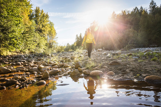 Female hiker walking on riverbed in Englishman River Falls Provincial Park , Vancouver Island, British Columbia, Canada