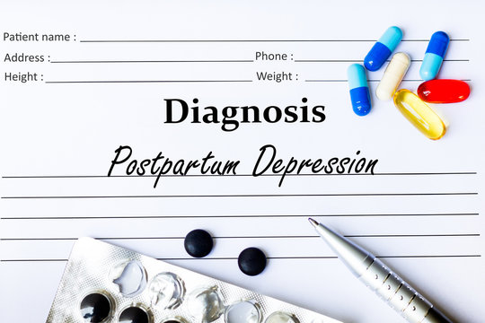 Postpartum Depression - Diagnosis written on a piece of white paper with medication and Pills