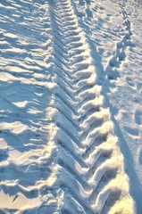 Fototapeta na wymiar Traces of automotive treads on the snow. Winter tires.