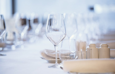 Empty glasses in restaurant. Cutlery on the table in a restaurant table setting, knife, fork, spoon, interior. Selective soft focus on Wine glass on dining table in restaurant.