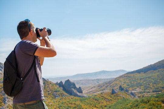 Guy photographing mountain in summer