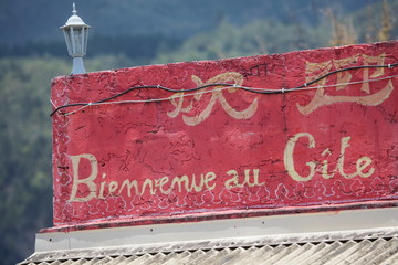 Red french language sign on bed and breakfast roof terrace wall, Reunion Island