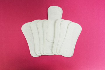 Sanitary pads on a pink background.