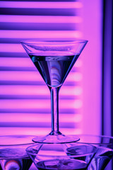 beautiful wine champagne glasse in front of colorful background with shades of pink.