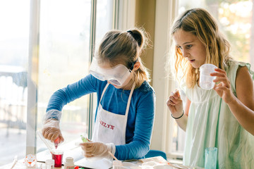Two girls doing science experiment, with red liquid