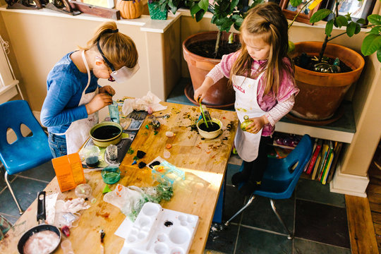Two girls doing science experiments at messy table