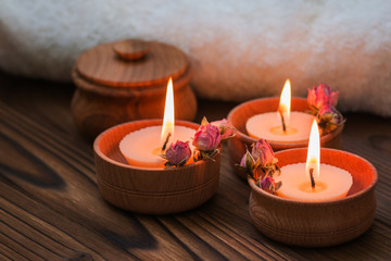 Fototapeta na wymiar Peach small candles in wooden cups with dried flowers