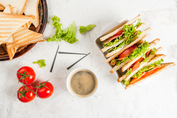 Breakfast with club sandwiches with fresh tomatoes, lettuce and cucumbers salmon (trout), coffee, on white stone concrete table close view copy space
