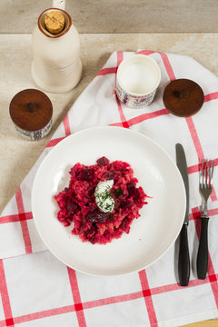 Risotto with beetroots, beets. Beige background, white plates.