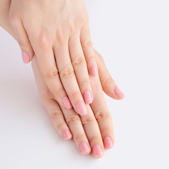 Closeup of hands of a young woman with pink manicure on nails