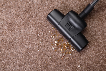 Vacuuming carpet with vacuum cleaner. Dirt on the rug. Housework service. Close up of the head of a...