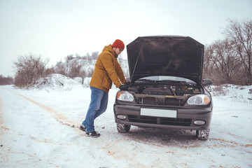 upset young men looking under the hood