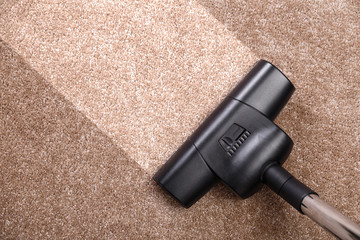 Vacuuming carpet with vacuum cleaner. Housework service. Close up of the head of a sweeper cleaning...