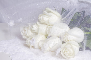 White dreamy cream rose bouquet with white netting with sparkles.  Elegant image.