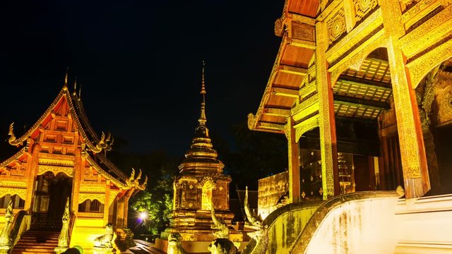 Chiang Mai, Thailand. Illuminated temples of Wat Phra Singh in Chiang Mai, Thailand at sunset. Golden walls and blue sky. Hyperlapse