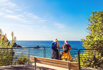 Two elderly women  backpacking near sea