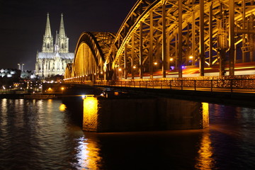 Fototapeta premium Lit up bridge and Cologne Cathedral