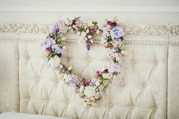 Heart of flowers as decoration in the bridal suite on the bed
