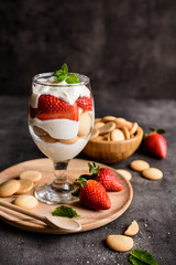 Delicious strawberry tiramisu with sponge biscuits in a glass jar