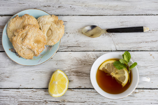 Cup of green tea with lemon and almond biscuits