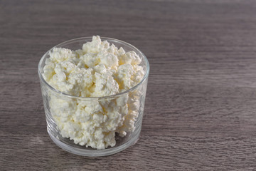 The cheese in the container on the table.