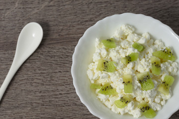 Soft cheese with pieces of fruit, kiwi.