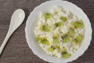 Soft cheese with pieces of fruit, kiwi.