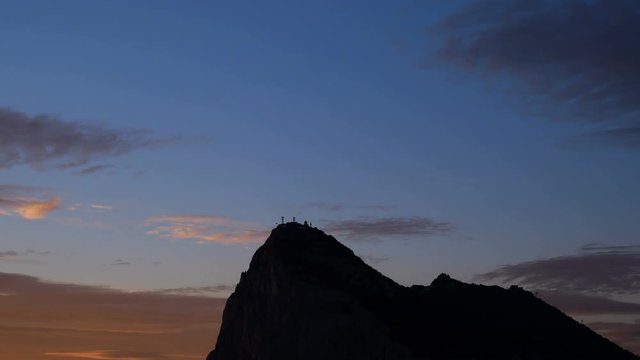 Sunrise time-lapse of the Rock of Gibraltar with morning cloudy sky, UK.