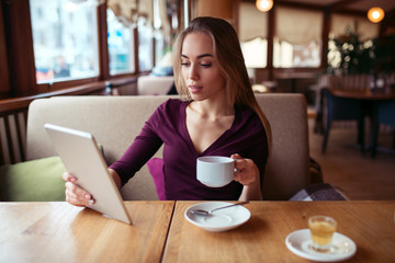 Female using wifi on tablet pc in cafe