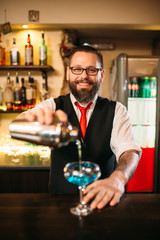 Bartender with shaker making alcohol cocktail