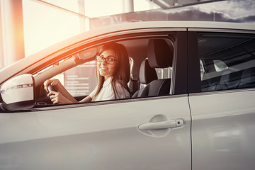 Naklejka premium Pretty young woman driving her new car.