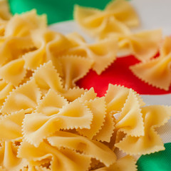 Traditional Italian cuisine. Close-up top front view. Dried Macaroni on the colors background of the Italian flag