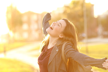 Excited girl raising arms in the street