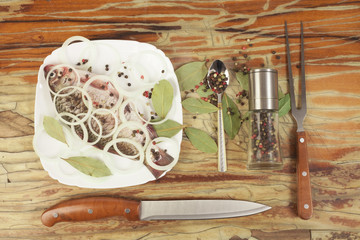 Fish on a white plate on a wooden background with seasoning