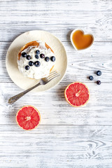 Breakfast concept with flowers on wooden background top view