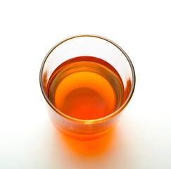 Glass of yellow beverage, top view