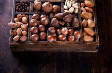 Nuts Mixed in a Wooden Vintage Box.Assortment, Walnuts,Pecan,Peanuts,Almonds,Hazelnuts,Macadamia,Cashews,Pistachios.Concept of Healthy Eating.Vegetarian.Copy space.selective focus.
