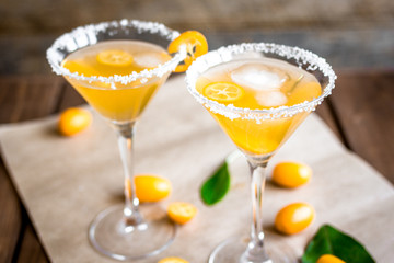 cocktail with kumquat on wooden background