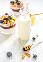 Fitness breakfast with muesli, honey and milk on white table