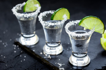 Set for tequila party with lime and salt on black background