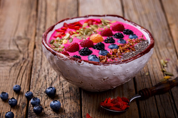 Berry Smoothie in the  bowl on a wooden Vintage Background.Detox. Breakfast Pudding topped with goji berries, and chia seeds.Concept of Healthy Food.Copy space. selective focus.