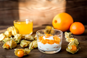 yogurt with physalis on wooden background
