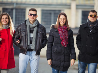 Two young couples are walking in the city