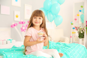 Obraz na płótnie Canvas Cute birthday girl sitting on bed with tasty cake