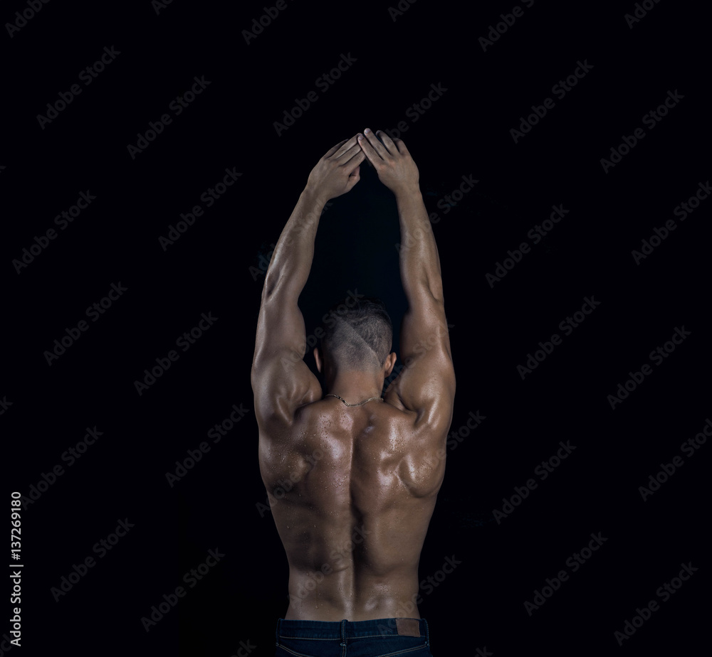 Wall mural Young attractive handsome muscular sexy bodybuilder back with raised hands