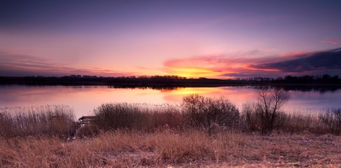 Beautiful sunset over spring lake landscape