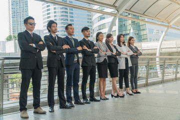 Team businessman standing arms crossed in the city.