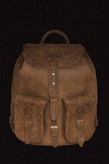 Brown leather bag, backpack handmade on a black background. Individual tailoring of leather. Handmade to order.