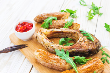 Grilled fish tilapia and chili plantains with arugula