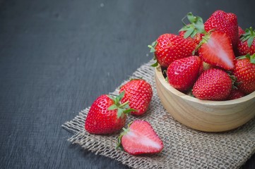 Fresh strawberry in wooden bowl on the table